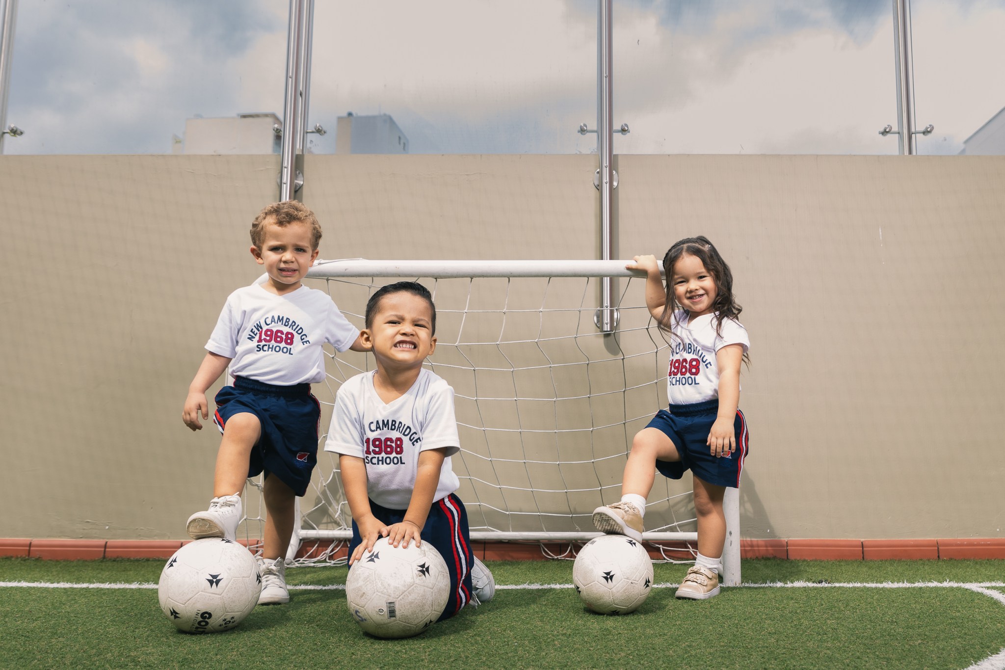 Estudiantes de Early Years en la cancha de Cabecera site, en la terraza, con balones a sus pies