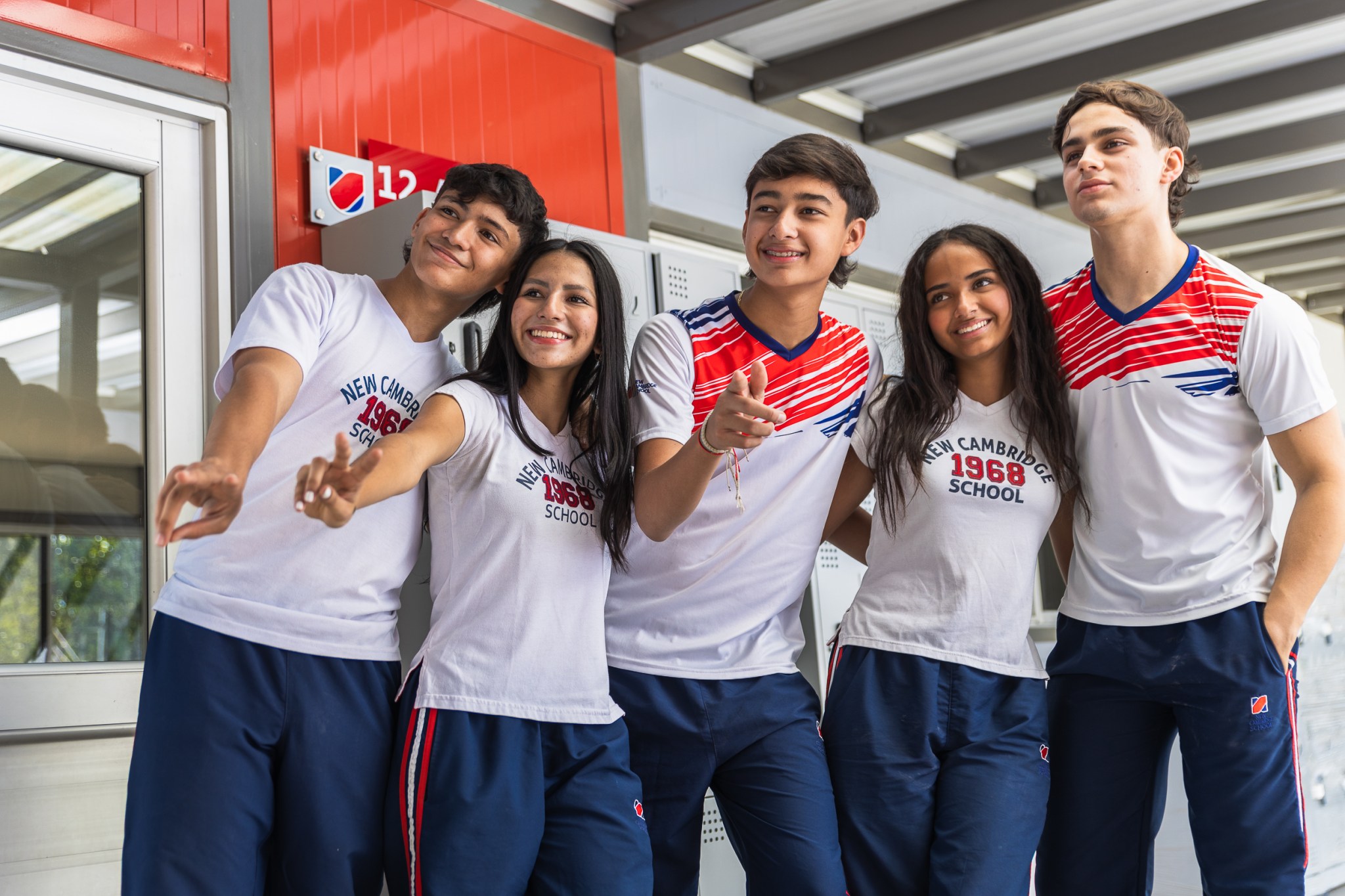 Estudiantes de PreU Campus abrazados, mirando hacia un lado, en plano medio abierto