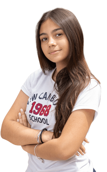 Estudiante de Lower Secondary, en plano medio, con los brazos cruzados. Sale ladeada y con camiseta institucional de 1968