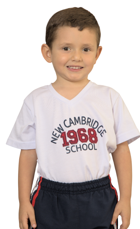 Estudiante sonriendo mientras mira a la cámara. Está usando camiseta blanca con letras azules y rojas