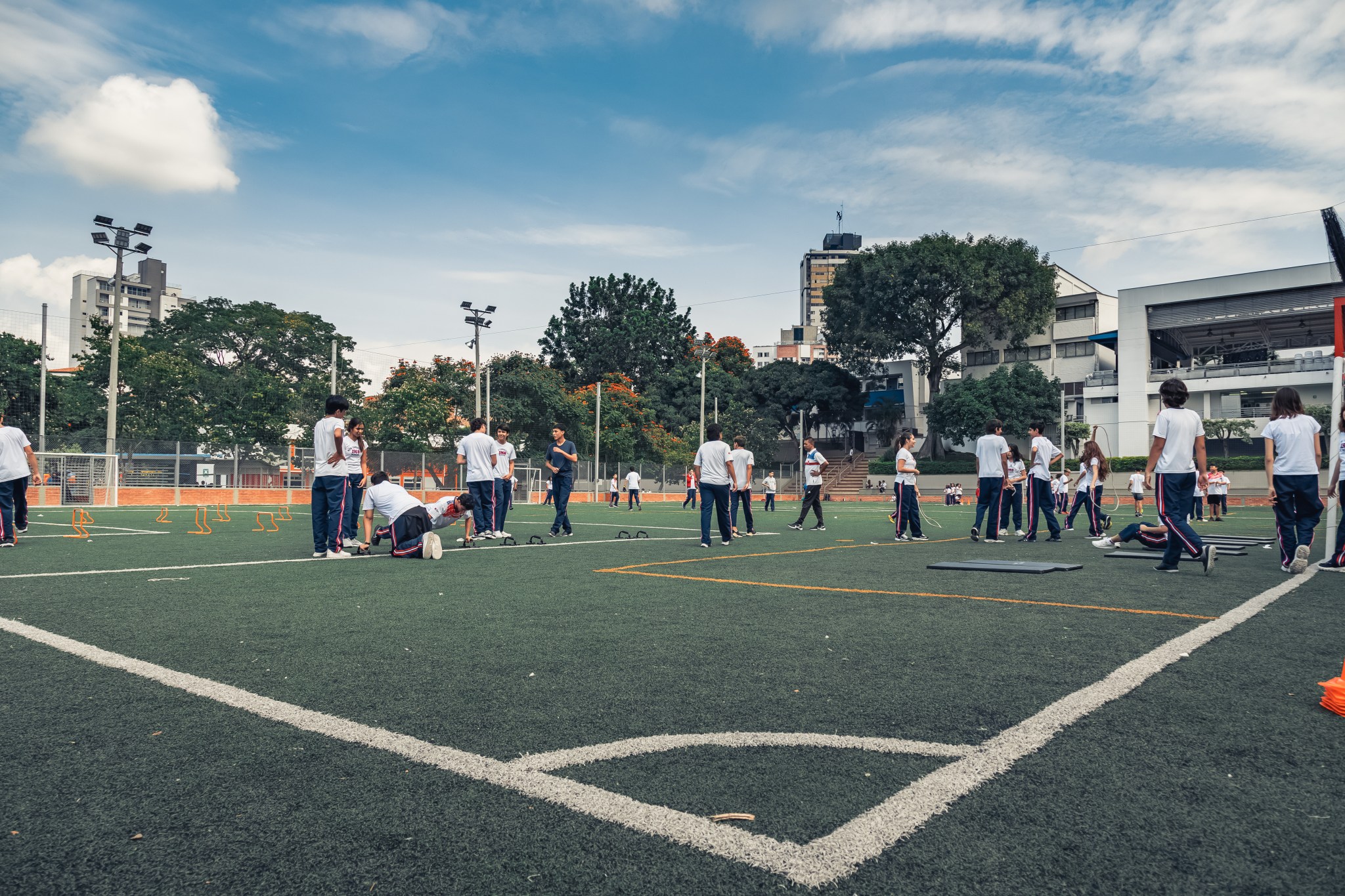 Cancha en la que hay varios estudiantes en sudadera y haciendo ejercicio