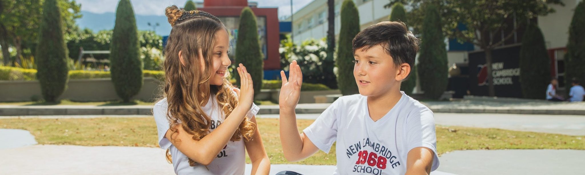 Estudiantes sentados en el aula viva de Cañaveral site, con las piernas cruzadas y chocando sus manos