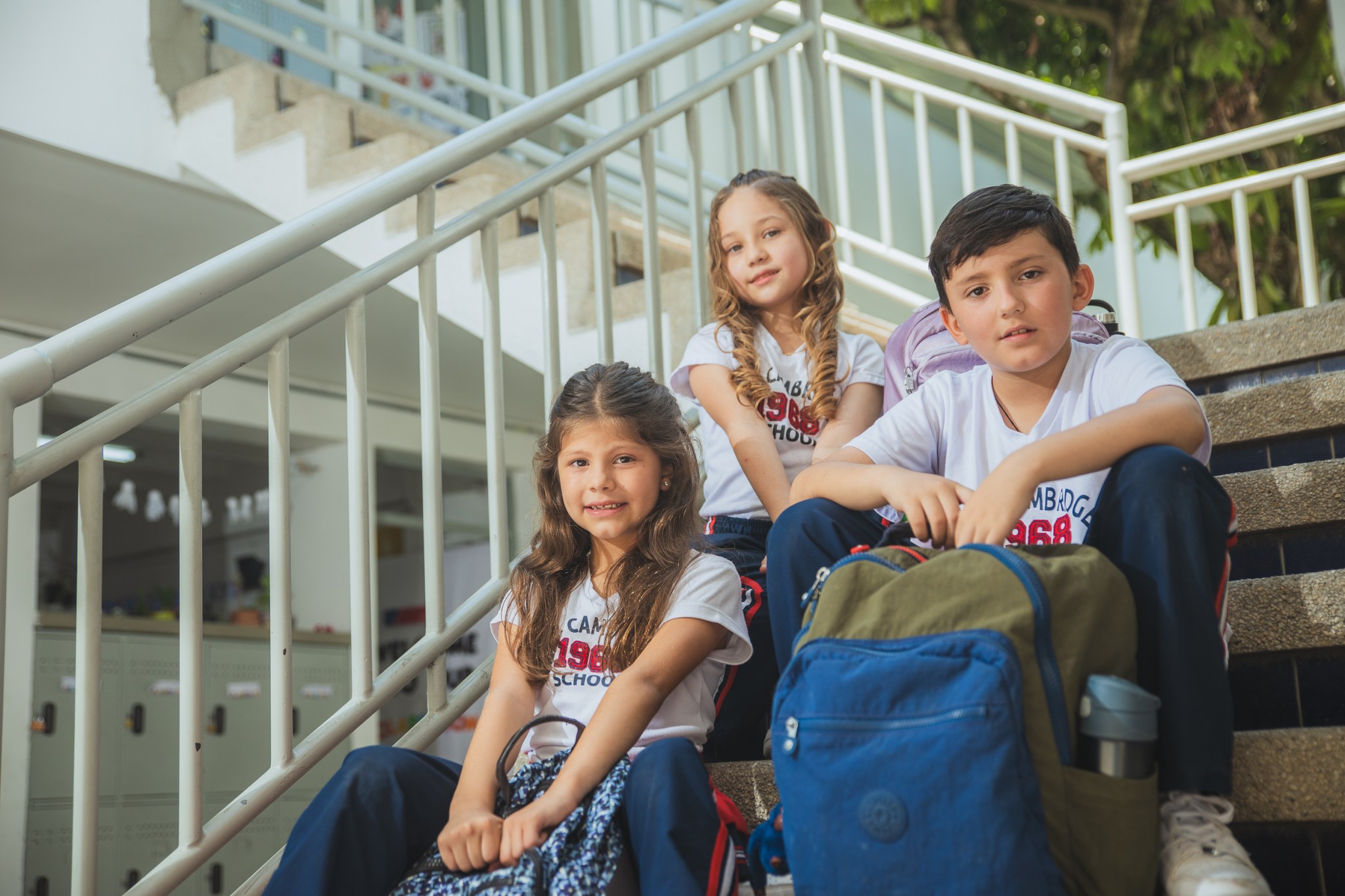 Estudiantes de Lower Primary sentados en las escaleras con sus morrales