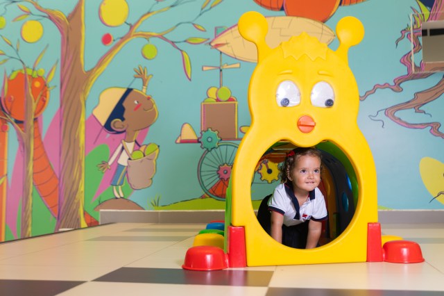 Estudiante sobresale de un túnel de gusanito infantil en Little Cambridge Cañaveral.
